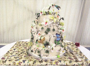 Wedding cake with hand-sculpted icing flowers, orchids and humming birds